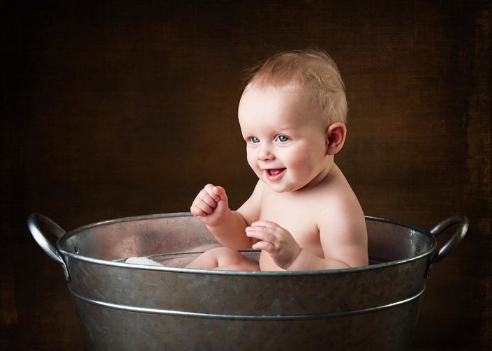 Photo of a baby sat in metal tub