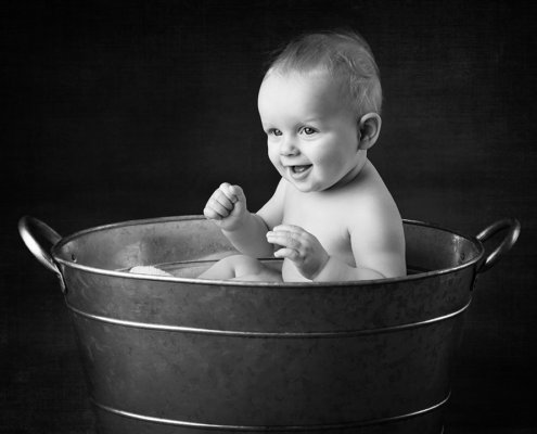 Baby in metal tub (photography studio).