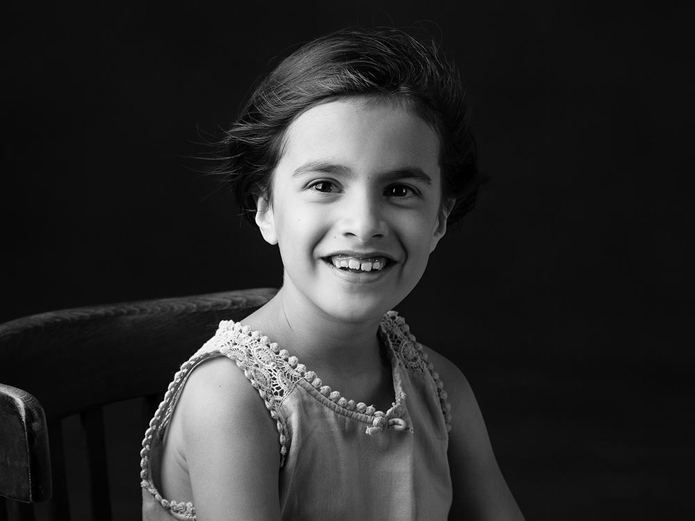 Monochrome portrait image of young girl in family photo studio