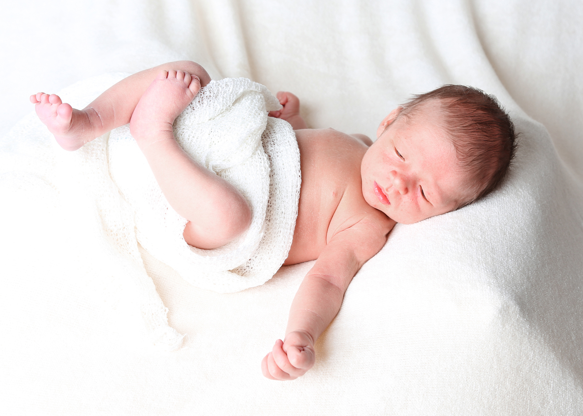 Newborn baby lying with a wrap