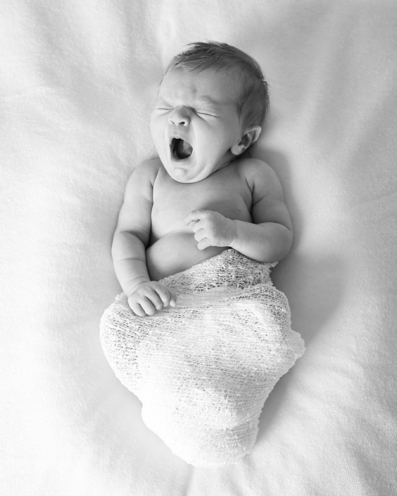 Newborn baby yawning in monochrome